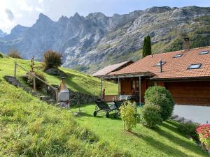 a house on a hill with mountains in the background at Holiday Home Reindli by Interhome in Innertkirchen