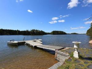 a dock on a lake with a boat in the water at Holiday Home Lövkulla by Interhome in Löparö