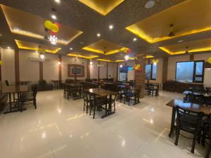 um restaurante com mesas e cadeiras num quarto em Hotel Broadway By WB Inn em Amritsar