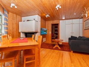 eine Küche und ein Wohnzimmer mit einem Tisch und einer Couch in der Unterkunft Holiday Home Valkeisrinne 1h by Interhome in Ruka