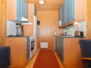 ルカにあるHoliday Home Valkeisrinne 1h by Interhomeのキッチン(青いキャビネット、赤い敷物付)