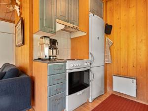 eine Küche mit einem weißen Herd und einem Kühlschrank in der Unterkunft Holiday Home Valkeisrinne 1h by Interhome in Ruka + 13 Fotos