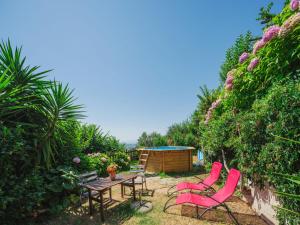a patio with pink chairs and a table in a garden at Holiday Home Il Mandarino by Interhome in Mommio