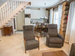a living room with a staircase and a dining room at Holiday Home Maahisenrinne 1 as 4 by Interhome in Äkäslompolo