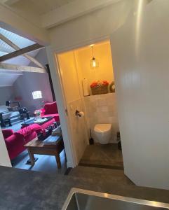 uma cozinha e uma sala de estar com um sofá vermelho em Gastenverblijf op de Prins Hendrik Hoeve in Buren em Buren