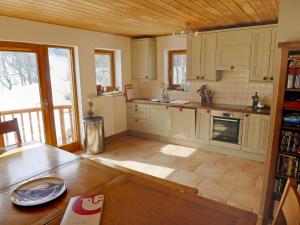 una cocina con armarios blancos y una mesa. en Holiday Home Chalet Eden by Interhome, en Blatten im Lötschental