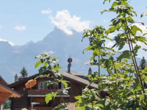 a view of a house from behind a tree at Apartment Goeland n-4 by Interhome in Villars-sur-Ollon