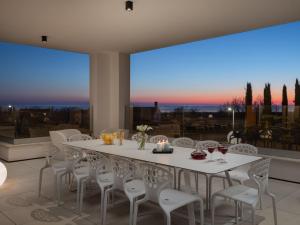 a dining room with a white table and chairs at Villa Old Olive I by Interhome in Vodnjan
