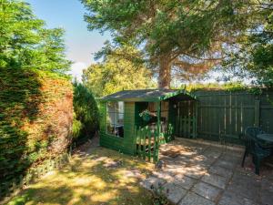 a green shed in a yard next to a fence at Holiday Home Broom Park by Interhome in Inverness