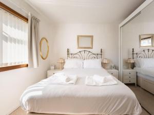 a white bedroom with a large white bed with white pillows at Holiday Home Broom Park by Interhome in Inverness