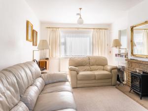 un soggiorno con divano e sedia di Holiday Home Broom Park by Interhome a Inverness