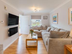 een woonkamer met een bank en een tv bij Holiday Home Sea Echo by Interhome in St Austell