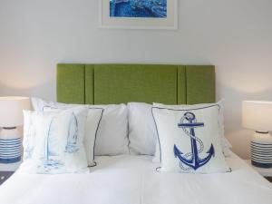 een bed met blauwe en witte kussens erop bij Holiday Home Sea Echo by Interhome in St Austell