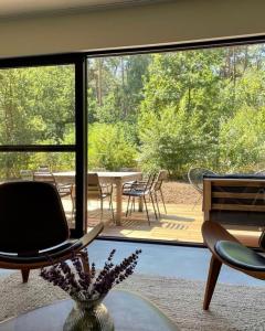 Habitación con ventana grande con mesa y sillas. en Osbos chalets en Lille