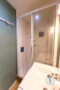 W łazience znajduje się prysznic i biała umywalka. w obiekcie Le P'ti Pau - Centre de Pau - Appartement lit double w mieście Pau +9 zdjęć