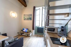 salon z kanapą i kuchenką mikrofalową w obiekcie Le P'ti Pau - Centre de Pau - Appartement lit double w mieście Pau
