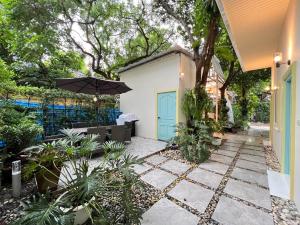 un patio con sombrilla y algunas plantas en Warm White Hua Hin House, en Hua Hin