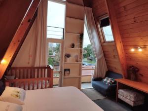 a bedroom with a bed and a large window at the Wooden A-frame in Hamilton in Hamilton