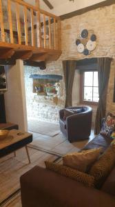 a living room with a couch and a staircase at Chocolate Box Cottage in Parzac