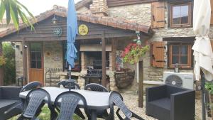 a table and chairs in front of a building at Chocolate Box Cottage in Parzac