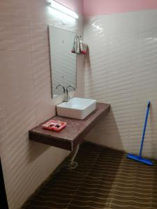 a bathroom with a sink and a mirror at Hotel Shresth in Pithorāgarh