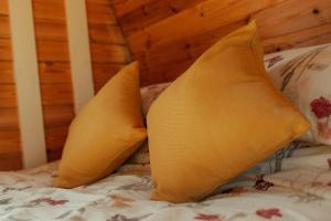 a pair of yellow pillows on a bed at Glamping in Wiltshire the Green Knoll is a charm in Chippenham