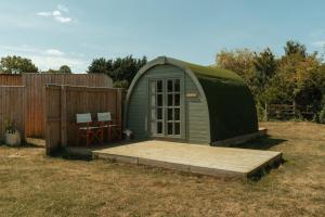 Casa con cúpula verde y patio con terraza de madera. en Glamping in Wiltshire the Green Knoll is a charm en Chippenham