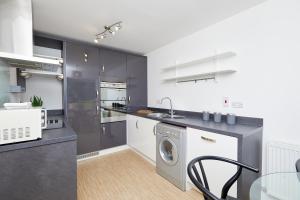 a kitchen with a washing machine and a dishwasher at Royal Derby Hospital Luxury House in Derby