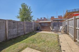 a backyard with a fence and a table and chairs at Royal Derby Hospital Luxury House in Derby