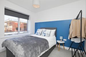 sypialnia z dużym łóżkiem i niebieską ścianą w obiekcie Royal Derby Hospital Luxury House w mieście Derby