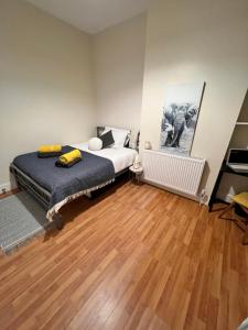 1 dormitorio con 1 cama y suelo de madera en Always the same price! Free parking, en Londres