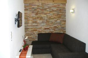 a living room with a couch and a brick wall at Landhaus Dangl in Fliess