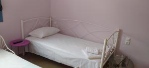 a white bed with a metal frame in a bedroom at Theros house in Kythira