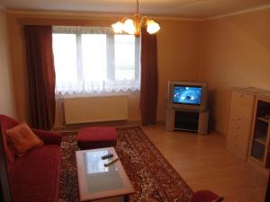 a living room with a couch and a tv at Apartment Bajt in Králíky