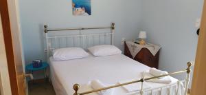 a bedroom with a white bed with white pillows at Theros house in Kythira