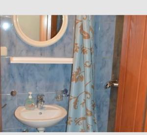 a bathroom with a sink and a shower curtain at Plava kuća in Međugorje