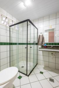 a bathroom with a glass shower and a toilet at Chalé Mares in Estância