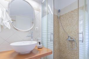 La salle de bains est pourvue d'un lavabo blanc et d'une douche. dans l'établissement Joanna's Old Town place, à Corfou