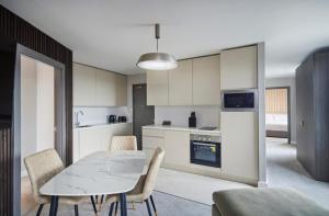 a kitchen and dining room with a table and chairs at LUSSO Macclesfield Serviced Apartments in Macclesfield