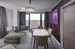 LUSSO Macclesfield Serviced Apartments في ماكليسفيلد: غرفة معيشة مع طاولة وأريكة