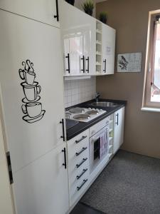 a small kitchen with white cabinets and a sink at Ferienwohnung Burgblick in Wiesbaden