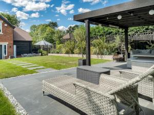 patio con 2 sedie in vimini sotto un padiglione di Delightful 3 Bed Country home with Large Garden a Abbots Langley