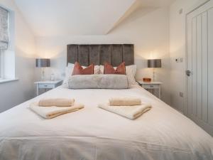 ein großes weißes Bett mit zwei Kissen darauf in der Unterkunft Delightful 3 Bed Country home with Large Garden in Abbots Langley