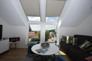 a living room with a table and a large window at Meeresblick-Storchennest-Haus-1-WE-13 in Hohwacht