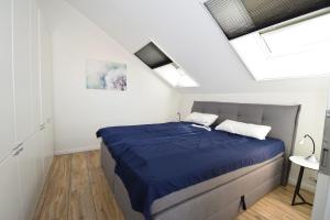 a bedroom with a bed with a blue comforter at Meeresblick-Storchennest-Haus-1-WE-13 in Hohwacht