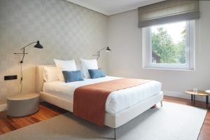 a bedroom with a bed with blue pillows and a window at Villa Jaizubia Golf by FeelFree Rentals in Hondarribia