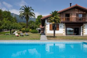 Villa con piscina frente a una casa en Villa Jaizubia Golf by FeelFree Rentals en Hondarribia