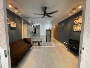 a living room with a couch and a ceiling fan at Galleria Equine Park - Studio in Seri Kembangan