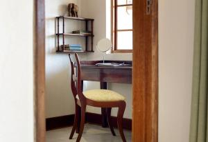 a desk with a chair and a mirror in a room at Tomjachu Bush Retreat in Nelspruit