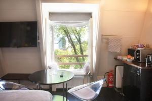 アムステルダムにあるズワンスタイン カナル ハウスのテーブルと窓が備わる小さな客室です。